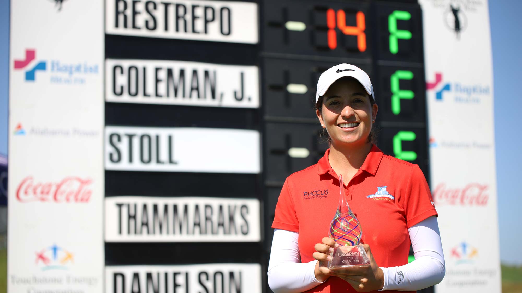Laura Restrepo with trophy at leaderboard 